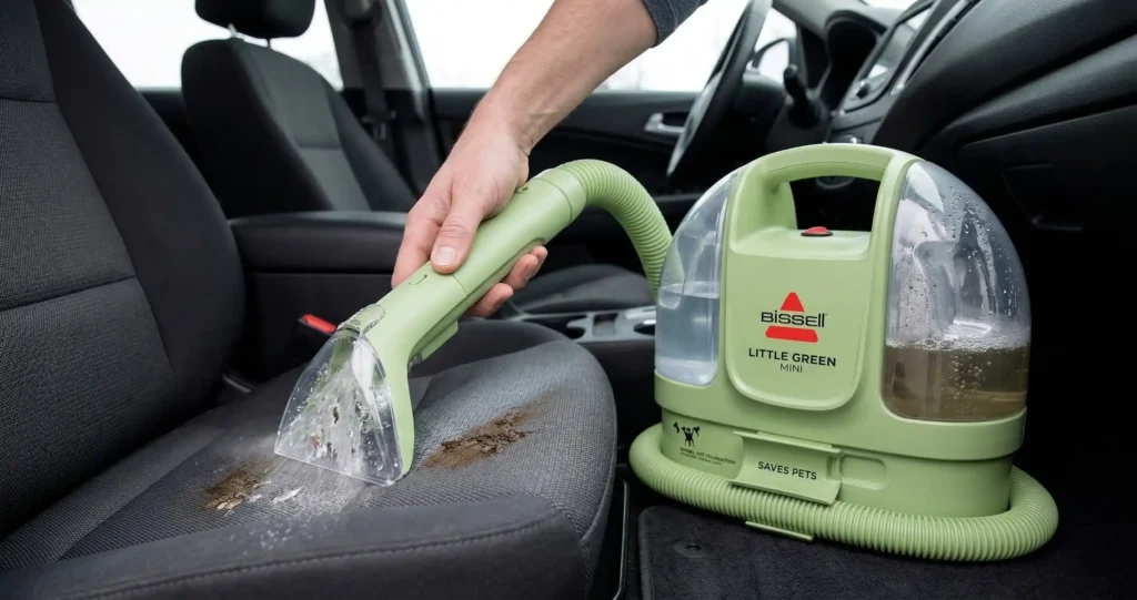 Bissell Little Green Mini Review 2026: Is This Portable Cleaner Still the Best? 3 A person using the Little Green Mini Bissell to deep clean a stained car seat upholstery with the portable spray and suction tool.