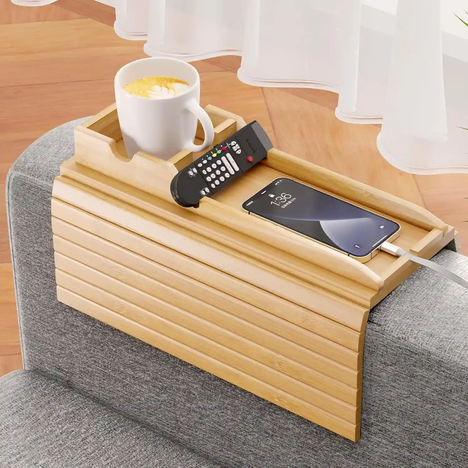Home 19 Flexible wood tray wrapped over a sofa armrest holding a phone and coffee mug.